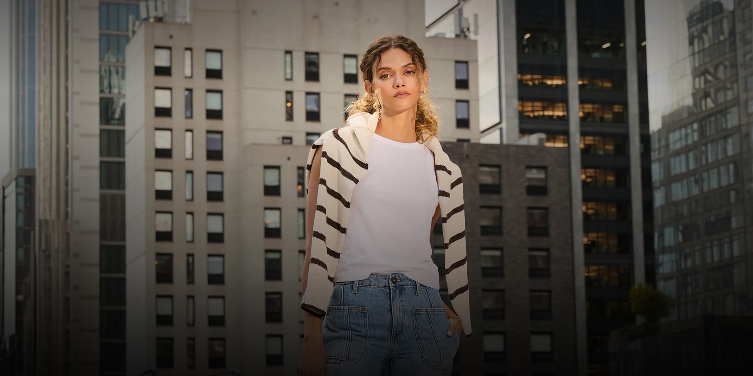 Person standing in front of a cityscape with tall buildings
